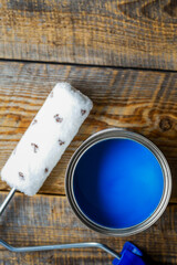 painting at home with can blue paint on wooden background