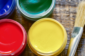 paint cans with brush on a wooden background top view