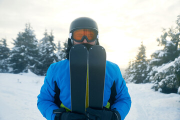 Skiing enthusiast preparing for a winter adventure in a snowy landscape during early morning hours. Winter sport