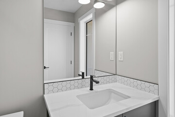 Bathroom with a white sink and a black faucet