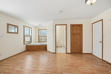 Large, empty room with a bathtub and a toilet