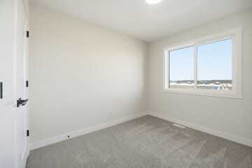 Very clean and empty bedroom with a large window