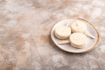 Сhocolate Ice cream in white glaze, on brown concrete, side view, copy space