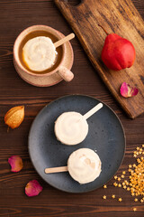Сhocolate Ice cream in white glaze, cup of coffee, on brown wooden, top view, flat lay, close up