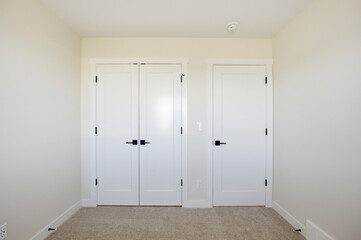 White room with two doors and a white wall