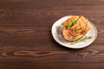 Fried Turkey Thigh with spices on plate on brown wooden. side view, copy space