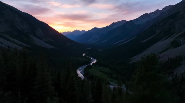 A scenic vista shows a valley with a river running between mountains at sunset, trees around