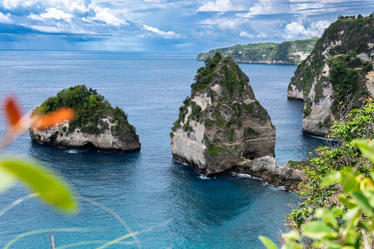 Nusa Penida, Indonesia – View of Diamond Beach with its turquoise water, white sand, and dramatic cliffs under bright tropical light. - Powered by Adobe
