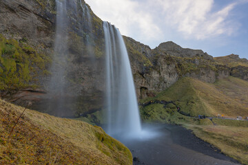 Skógafoss thunders down with unstoppable force, often crowned by a rainbow—a true Icelandic...