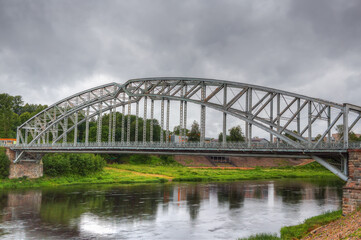 Arched bridge made of metal structures in the city of Borovichi, Russia.
