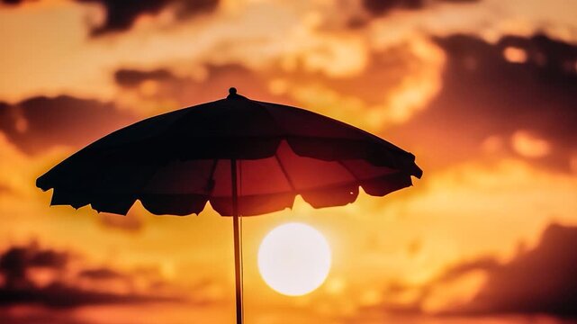 A colorful beach umbrella stands out against a warm sunset sky