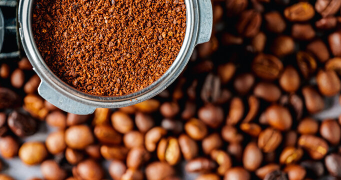 Ground coffee in portafilter or coffee ground in portable filter handle and coffee beans, Top view