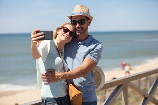 happy man and beautiful woman taking selfie photo
