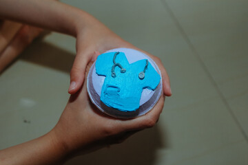 hand holding a cupcake with a doctor's uniform decoration on top