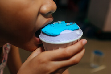 close up of mouth eating a decorated cupcake