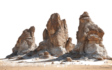 Rugged rock formations rise from a desert expanse against a clear sky, isolated from any background