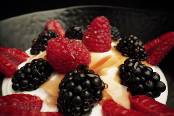 Yogurt with blackberries and raspberry fruits and honey                               