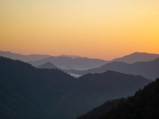 A mountain range at sunset with a golden sky.
