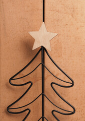 Metal Christmas tree shape with wooden star shape on a rustic wooden background