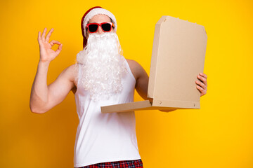 Santa in sunglass white tank top plaid shorts holds pizza box at home delivering funny holiday energy Christmas promotion festive lifestyle imagery