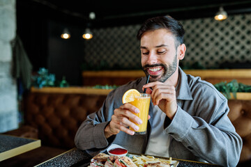 Young man enjoying eating lunch at restaurant