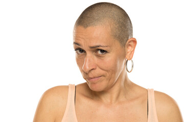 Fototapeta premium Studio shot of bald woman in tank top with skeptical and doubtful expression on white background.