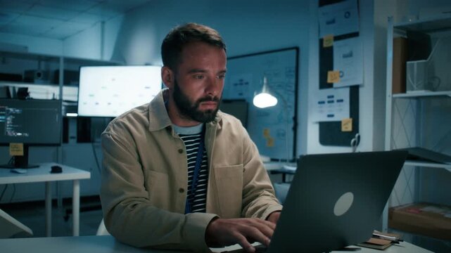 Focused Male Programmer, Software Developer working on Desktop Computer, looking at Screen sits at office workplace. Professional IT Programmer Developing Application, Program Writing code at Office.