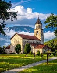 Scenic church nestled in a valley, surrounded by mountains and trees