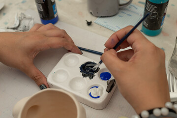 Detalle de manoscon pincel para pintar artesan&iacute;as