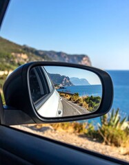Scenic coastal road viewed in a car side mirror