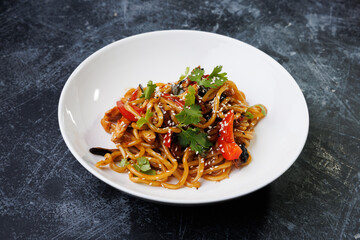 Spicy noodles with chicken, peppers, fresh herbs, and sesame seeds