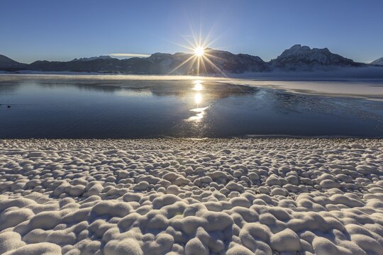 Sunrise at a lake in front of mountains, snow, winter, Forggensee, K&ouml;nigswinkel, view of Tegelberg and S&auml;uling, Alpine foothills, Upper Bavaria, Bavaria, Germany