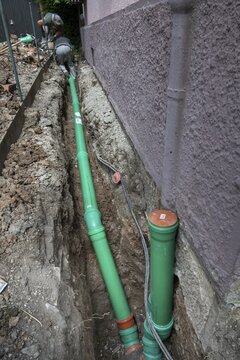 Construction worker, newly laid green sewage pipes, trench, Stuttgart, Baden-W&uuml;rttemberg