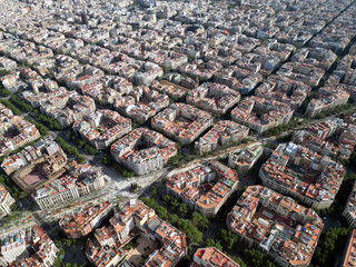 Aerial view of Barcelona Eixample residential district and Sagrada Familia Basilica at sunrise. Catalonia, Spain. Cityscape with typical urban octagon blocks