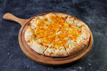 Cheesy Baked Pizza On Wooden Paddle Served On Dark Textured Tabletop