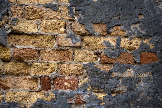 Grey plaster crumbling from a dilapidated brick wall, Venice, Veneto, Italy