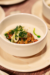 A bowl of food with a green garnish on top