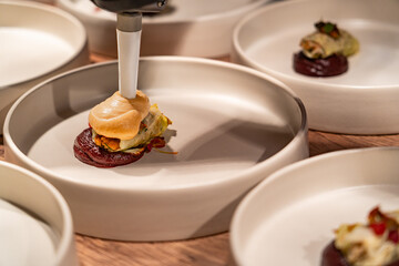 A white plate with a food item on it and a white bowl with a food item on it