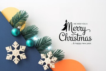 Evergreen boughs, turquoise ornaments, and paper snowflakes frame a holiday wish elegantly displayed