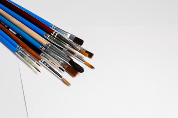 Brushes of various sizes and functions on a white background, creative artist tools. Background for advertising creative professions