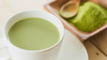 Creamy matcha latte with bamboo whisk and powder