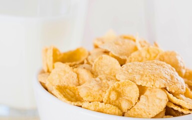 Crispy corn flakes cereal in a white bowl with milk