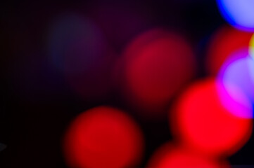 Red and blue lights with a bokeh effect on a dark background close up.