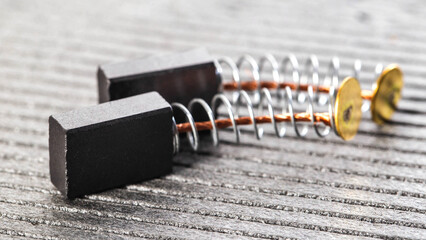 New brushes for replacement in an electric motor on a gray background, close-up, industry
