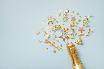 Celebration background with golden champagne bottle, confetti stars and party streamers. New Year, Christmas, birthday or wedding festive card. © juliasudnitskaya