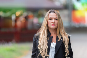Confident woman walking in urban setting during day, showcasing fashion and style