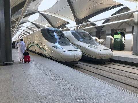 MEDINA, KINGDOM SAUDI ARABIA (KSA) - MAY 27, 2019 : An unidentified muslim pilgrim man walks by train coach at HSR Madinah station. The train model is Talgo 350SRO manufactured by Talgo and Renfe.