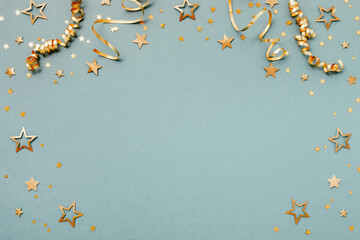 New Year, Christmas or birthday festive background top view. Celebration composition with golden confetti stars and serpentine party streamers.
