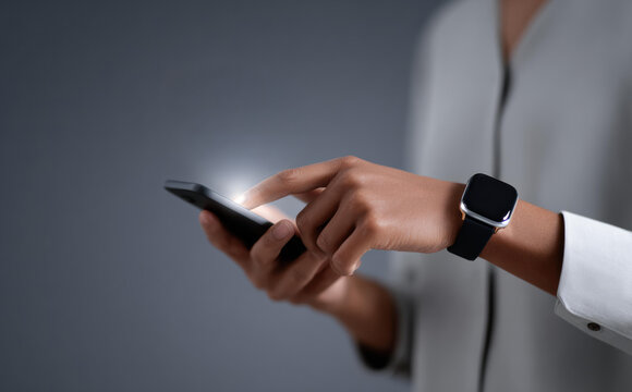 Focused businesswoman touching glowing smartphone screen. close up on hand using digital technology for business communication and connection, wearing smartwatch