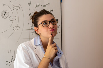 Woman teacher thinking about complex formulas and atomic structures on a whiteboard, problem solving in science education, contemplating a challenging question